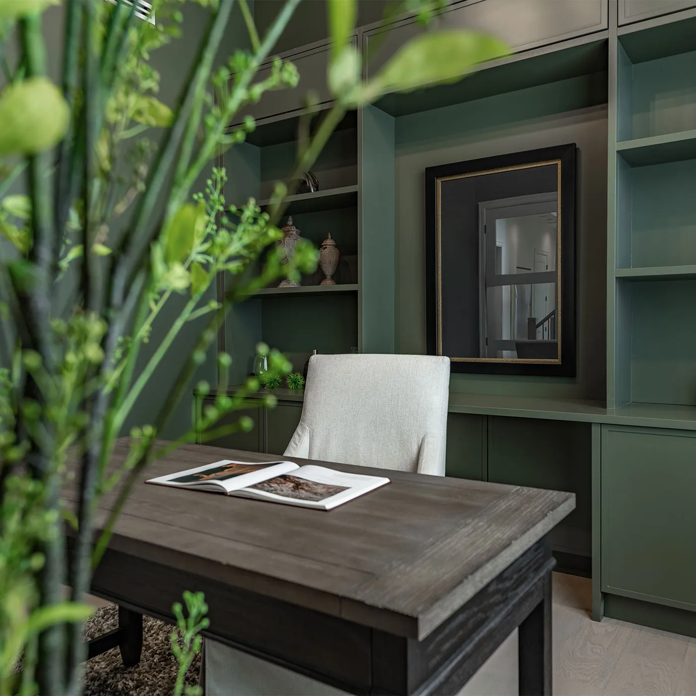 Custom built-in cabinetry and shelving in a deep green home office